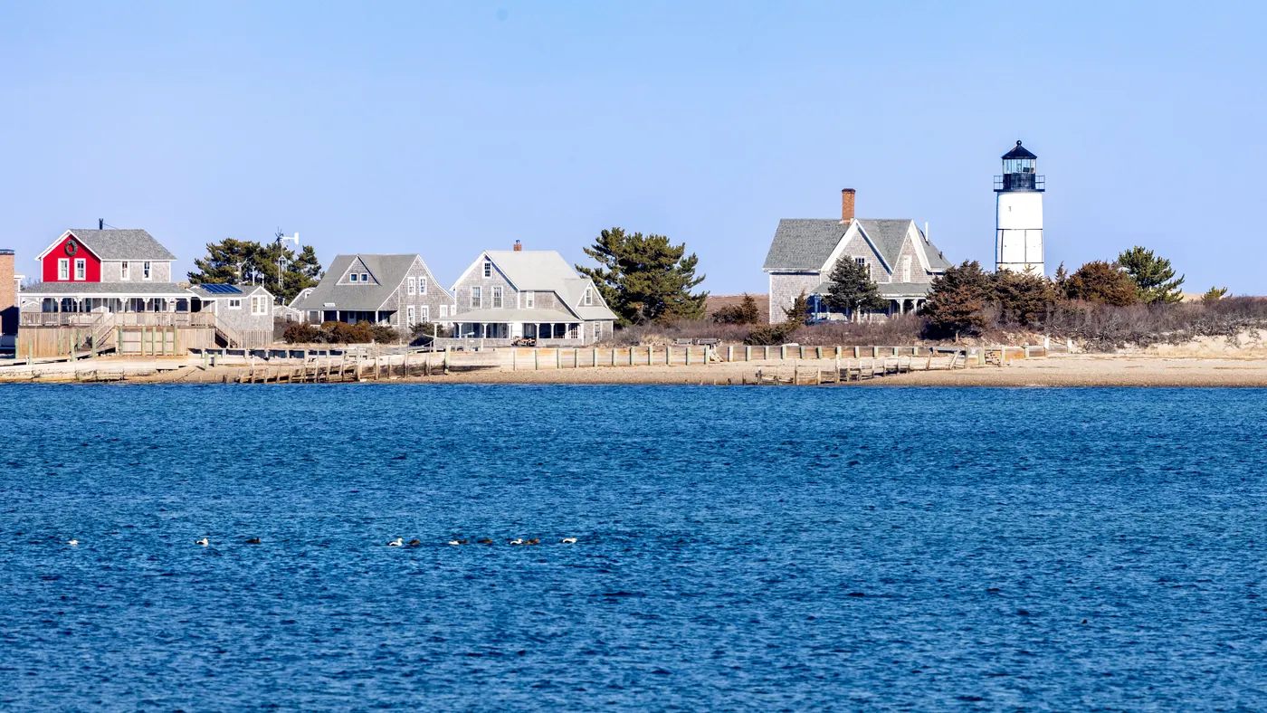 A lighthouse standing above the shoreline on Cape Cod