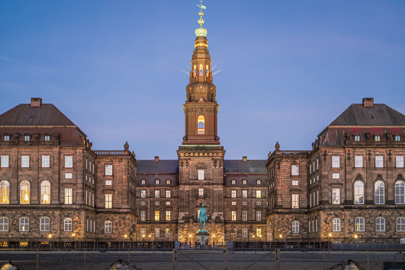 Christiansborg Palace and its tower lit up at dusk in Copenhagen