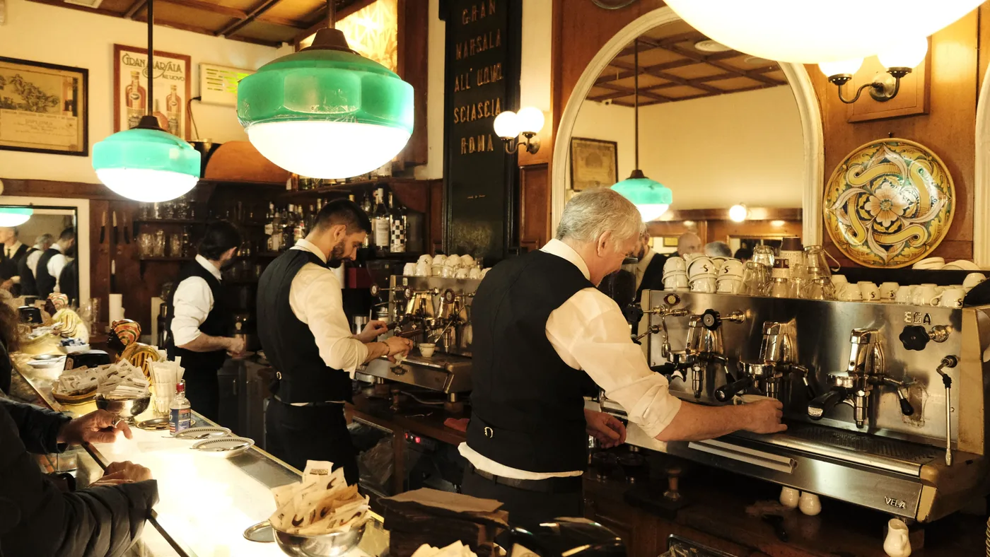 Baristas working the counter of an old Italian cafe