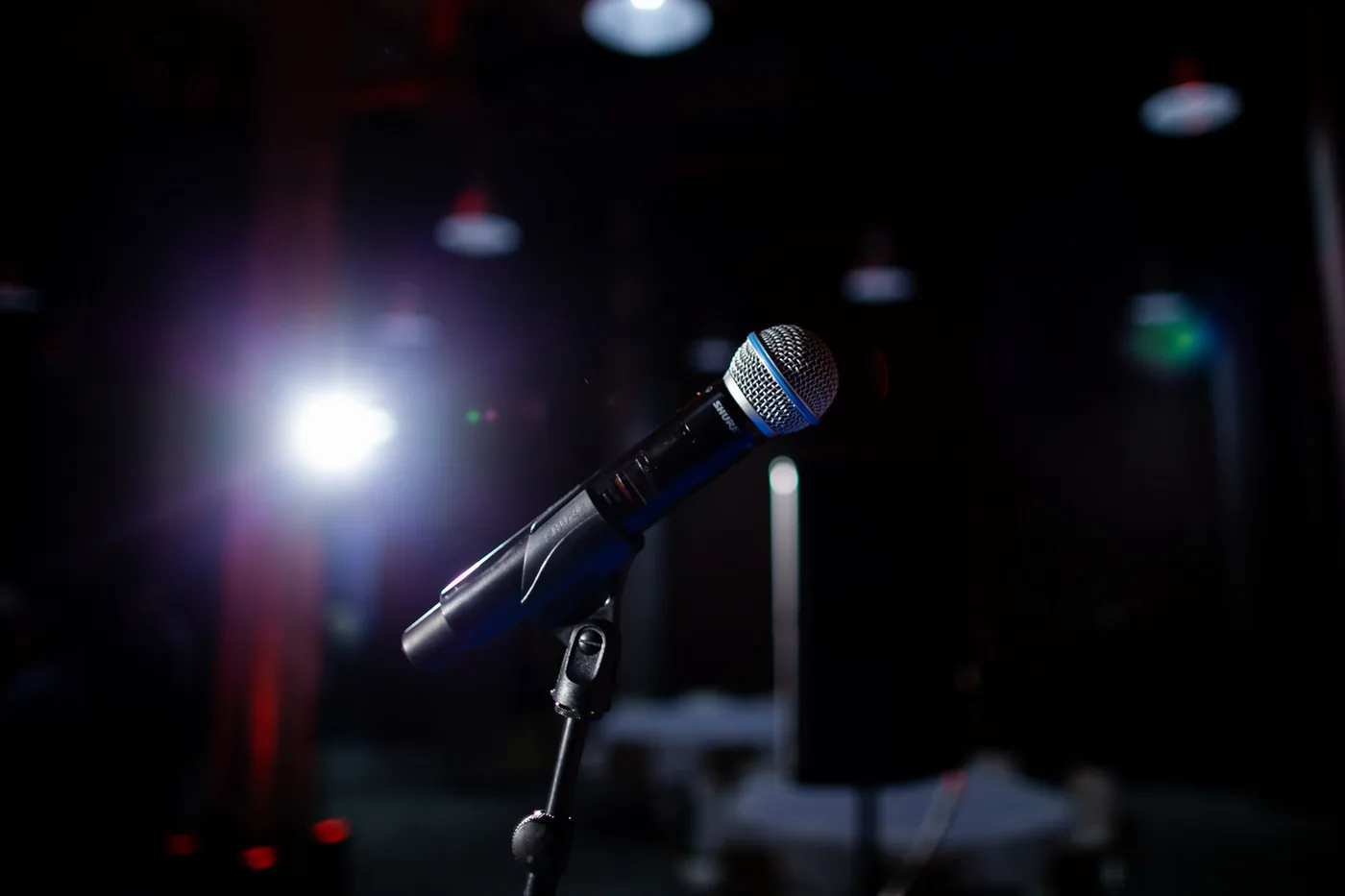 A microphone on a stand under a stage light