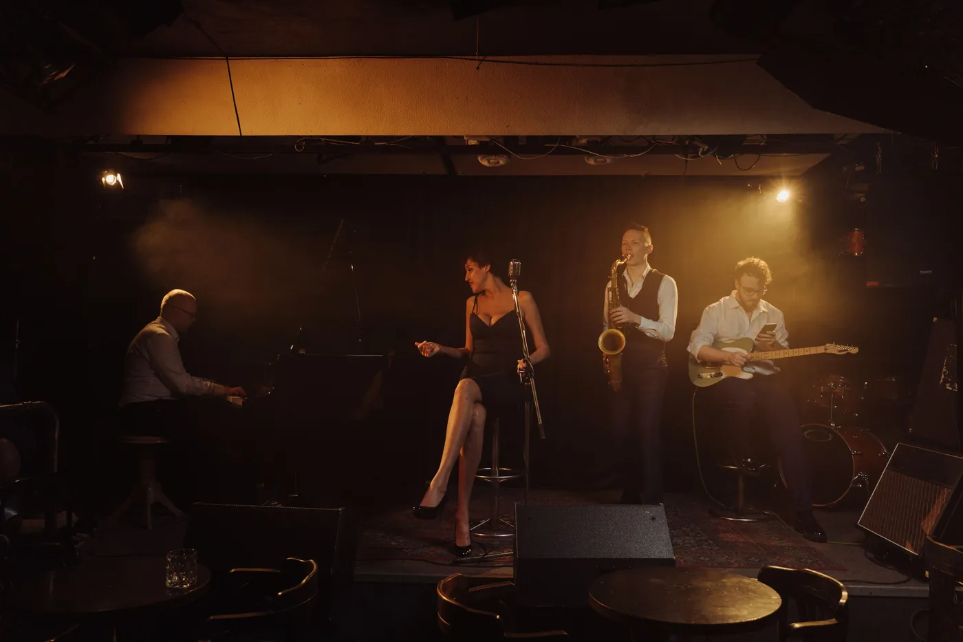 A jazz band playing to a small crowd in a dim club