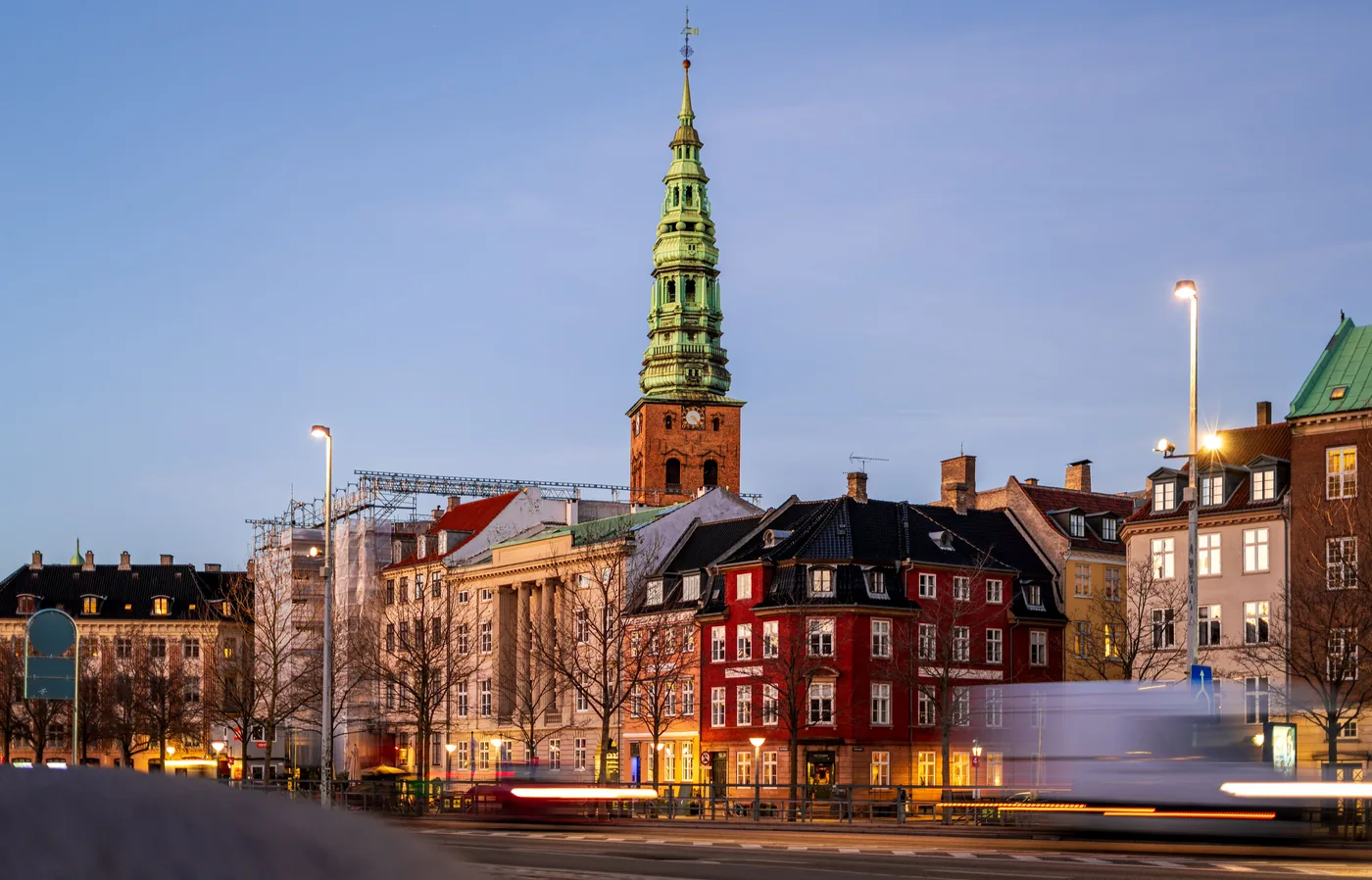 The Nikolaj Kunsthal spire above a Copenhagen street at dusk