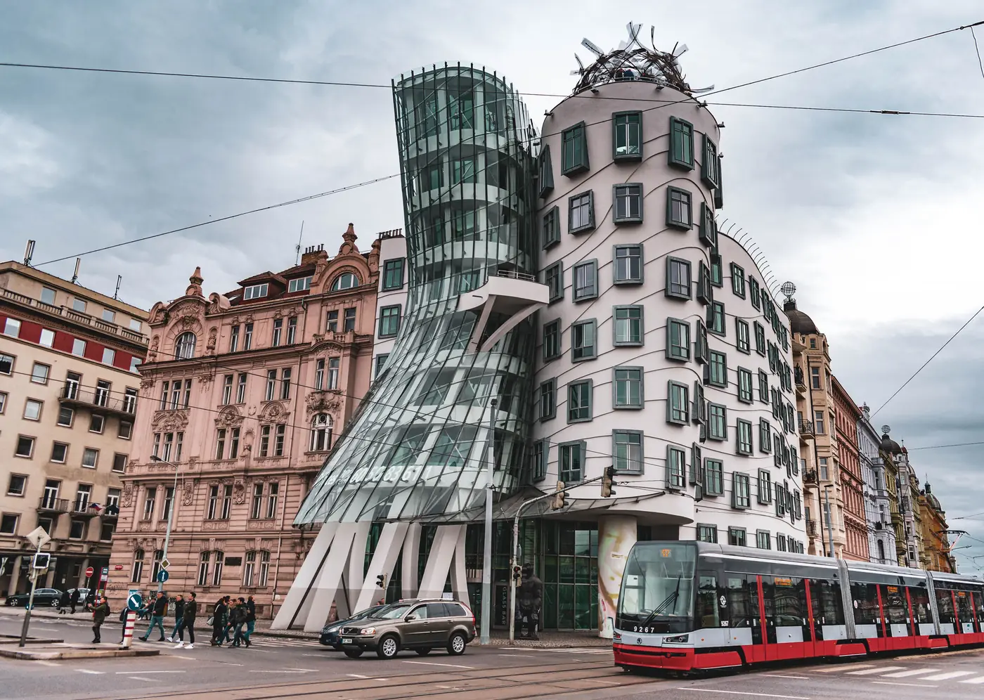 The Dancing House on the riverfront in Prague with a tram passing