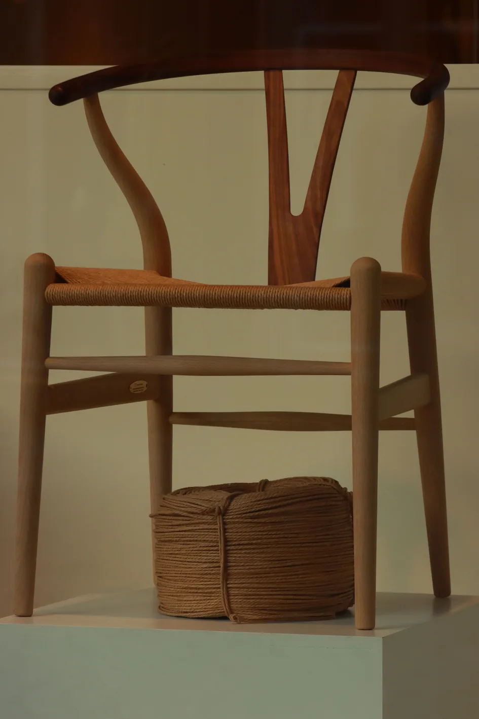 A wooden Wishbone chair with a woven paper cord seat, a Danish design classic