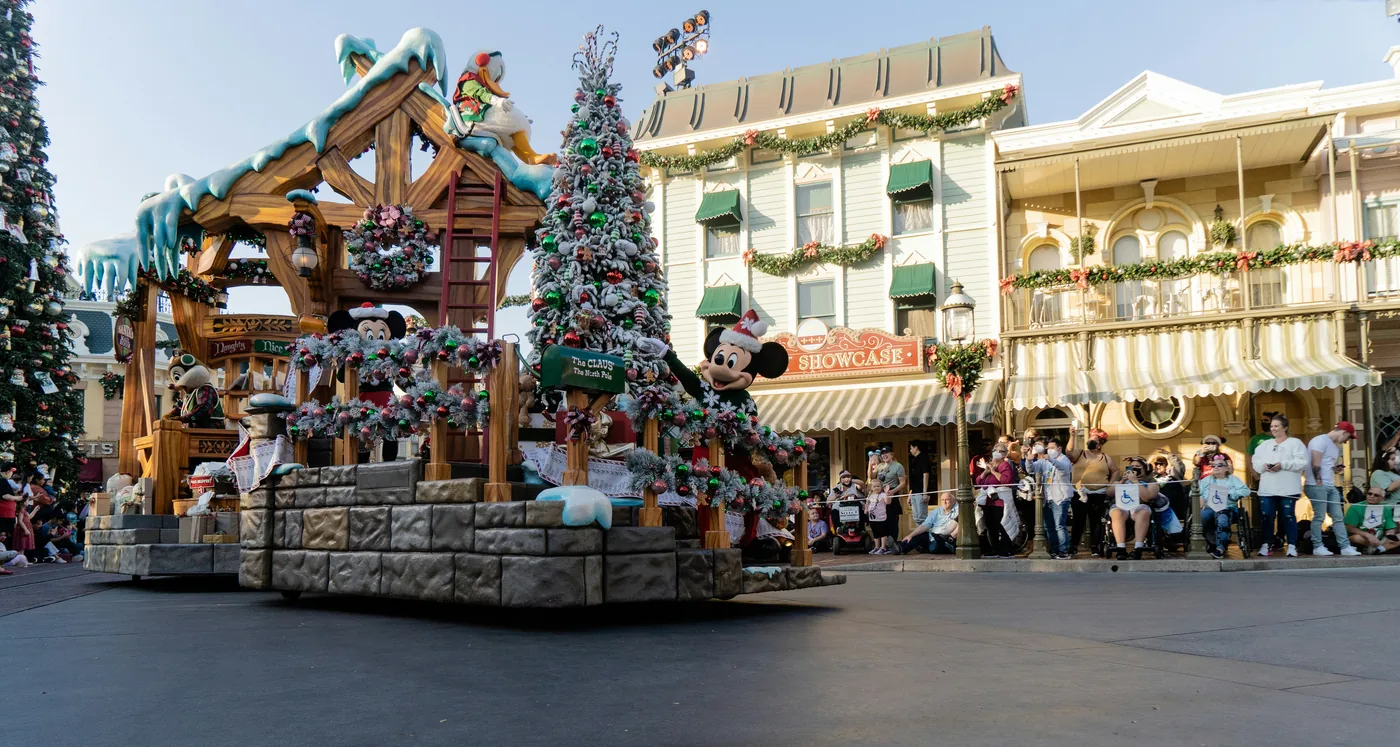 A float from A Christmas Fantasy Parade rolling past decorated buildings on Main Street at Disneyland