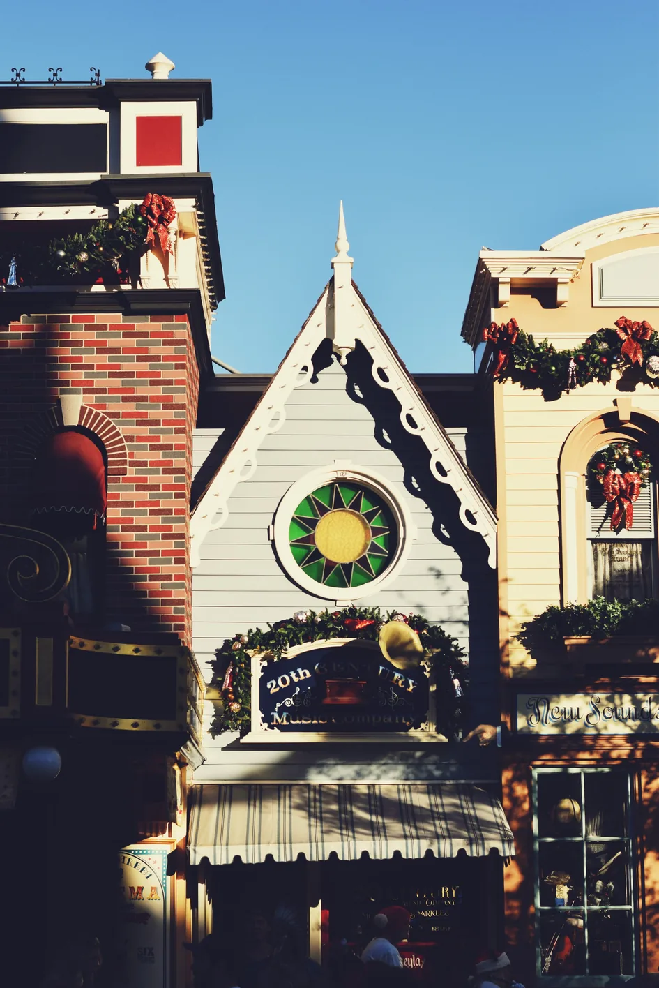 Main Street buildings at Disneyland decorated with Christmas wreaths and garlands