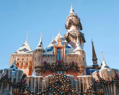 Sleeping Beauty's Winter Castle at Disneyland decorated with snow covered turrets, wreaths and holiday lights