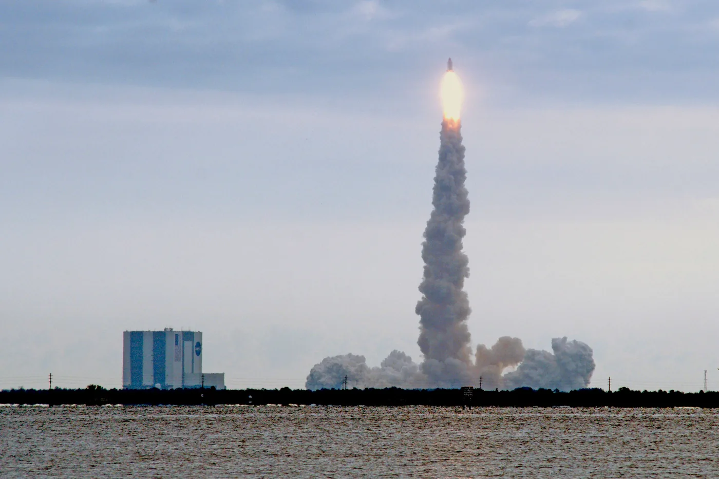 A rocket lifting off over the water at Kennedy Space Center