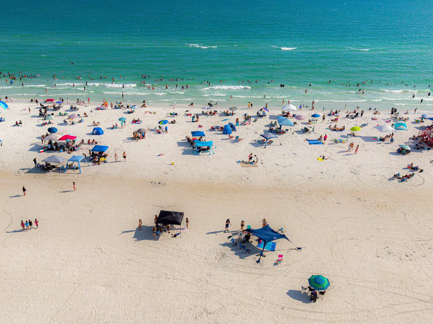 An aerial view of beachgoers on the white sand of Siesta Key