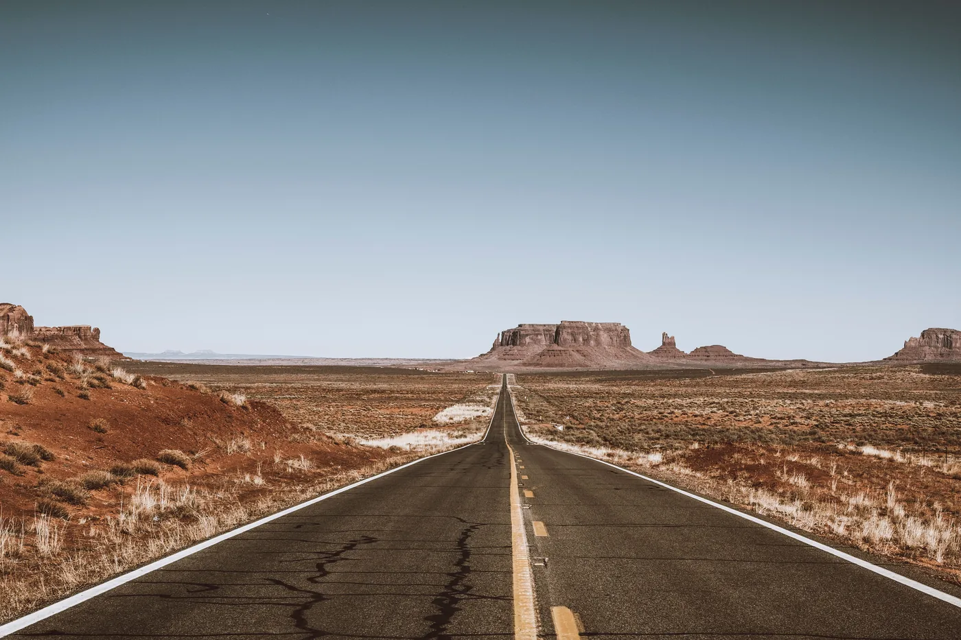An empty highway crossing the desert toward Monument Valley
