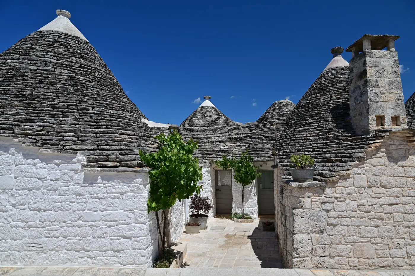 Whitewashed trulli houses with conical stone roofs in Alberobello, Puglia