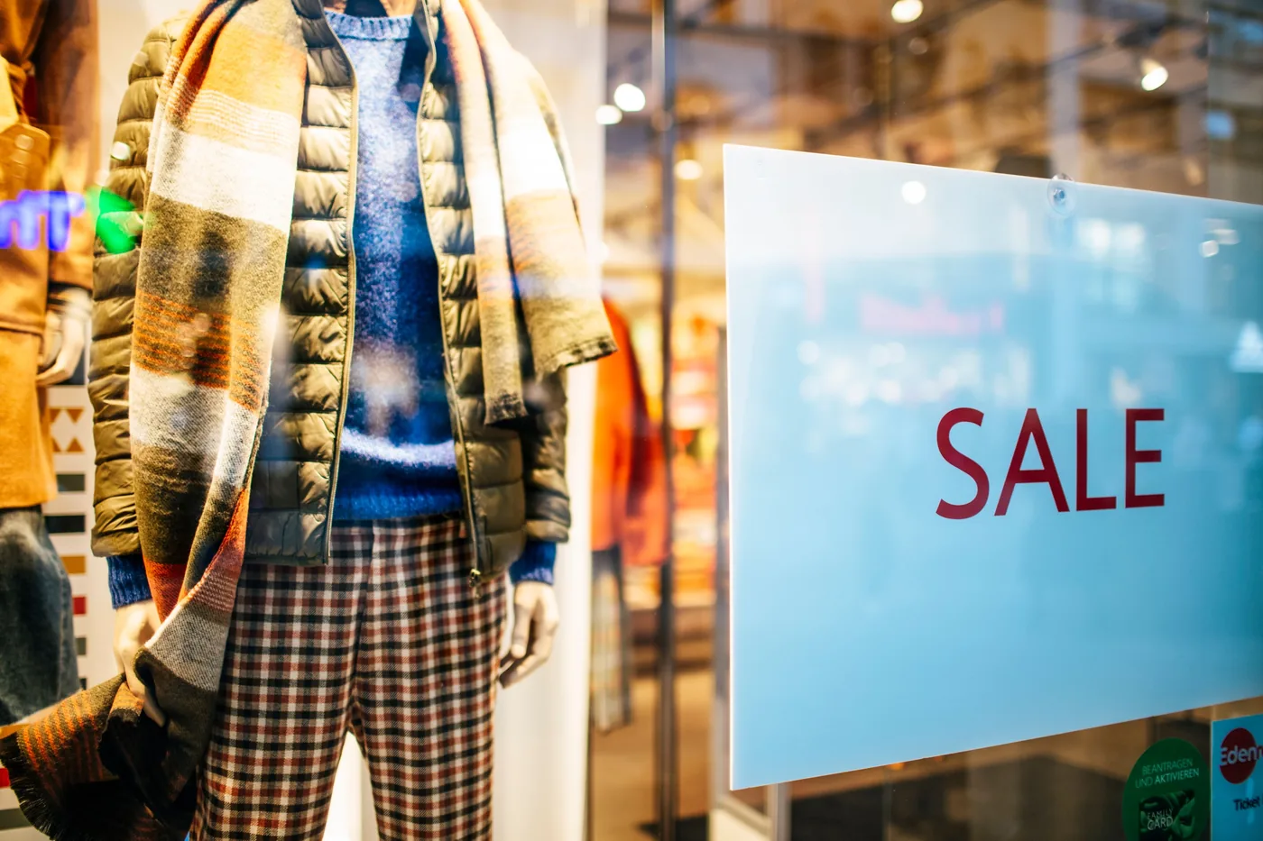 A sale sign in a clothing shop window