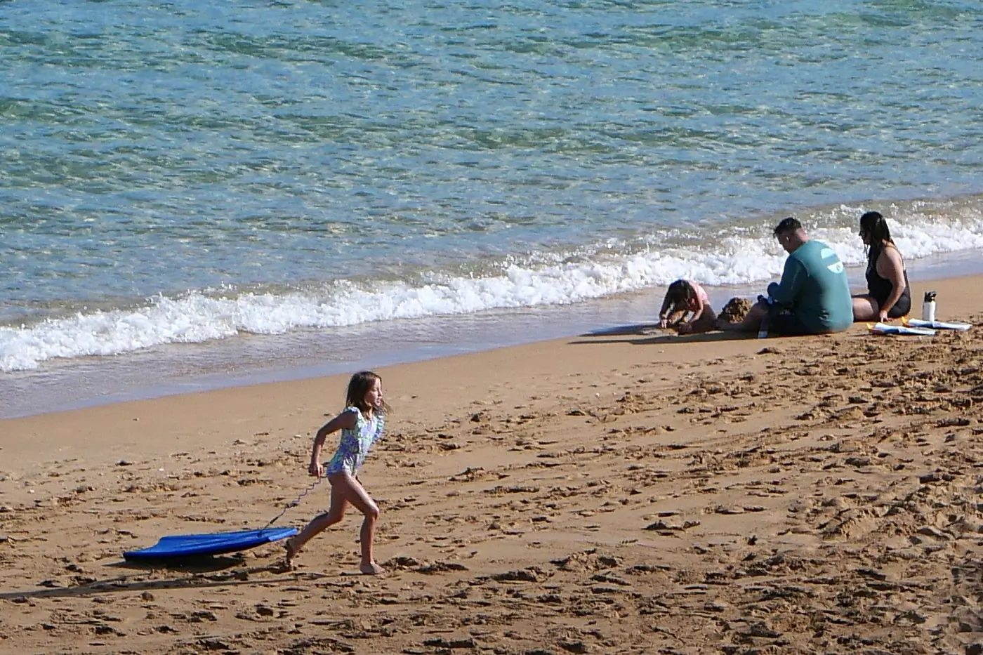 A family playing in the sand on Kaʻanapali Beach