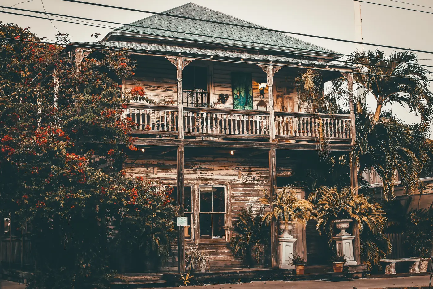 A weathered wooden house with a wide porch and tropical plants in Key West