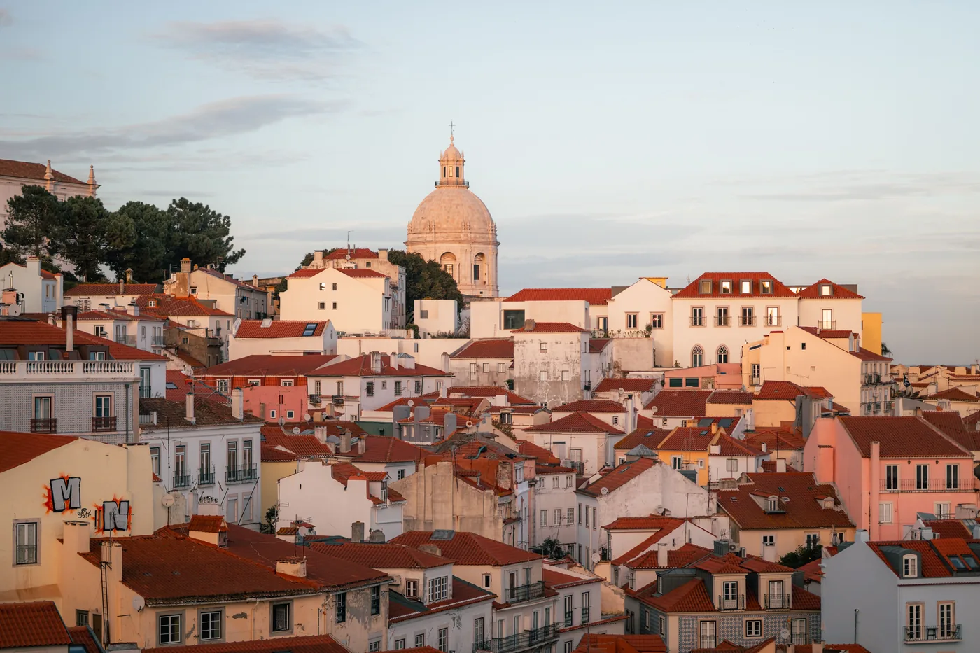 Alfama's rooftops glowing at sunset in Lisbon