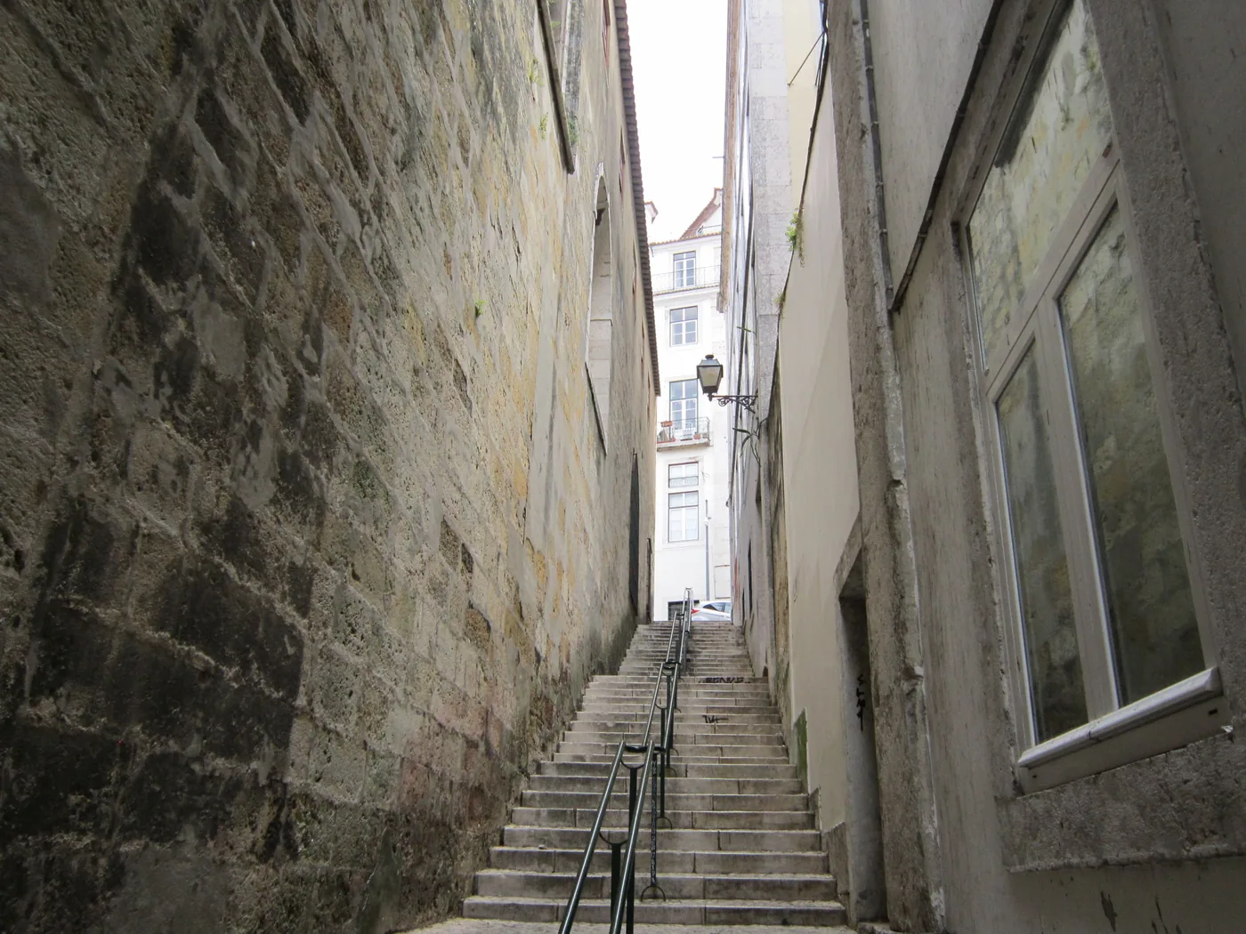 A narrow stepped alley climbing uphill in Lisbon