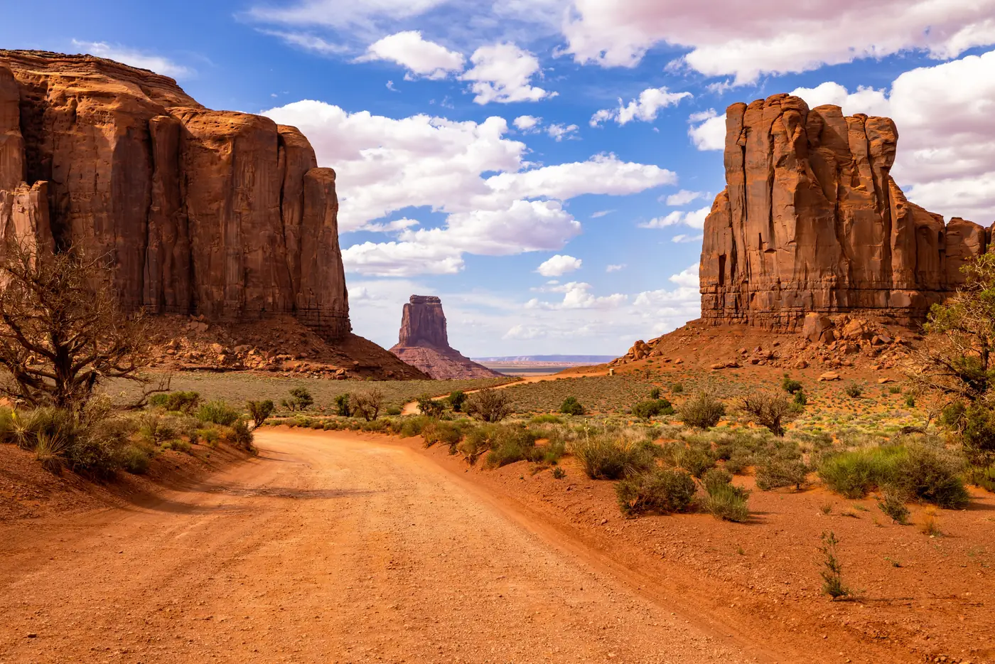 The dirt Valley Drive running between rock formations in Monument Valley