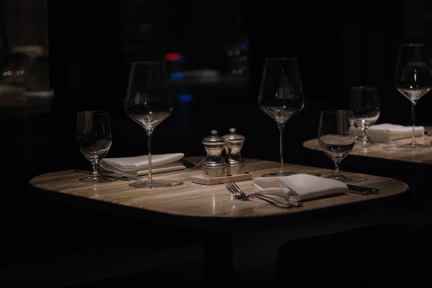 Wine glasses set on a dark restaurant table in New York