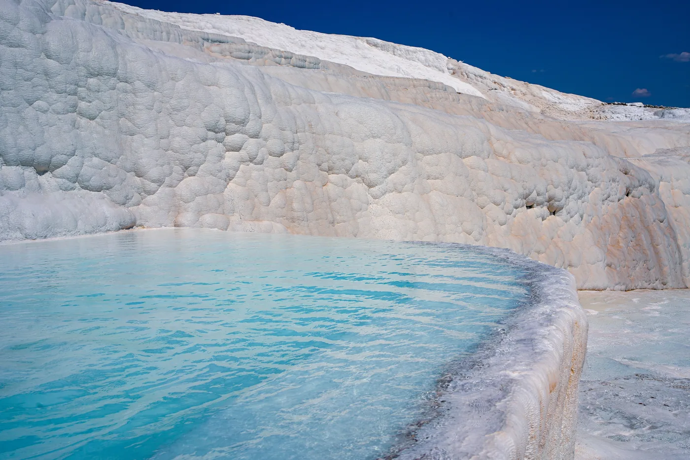 A blue pool on the white travertine terraces at Pamukkale