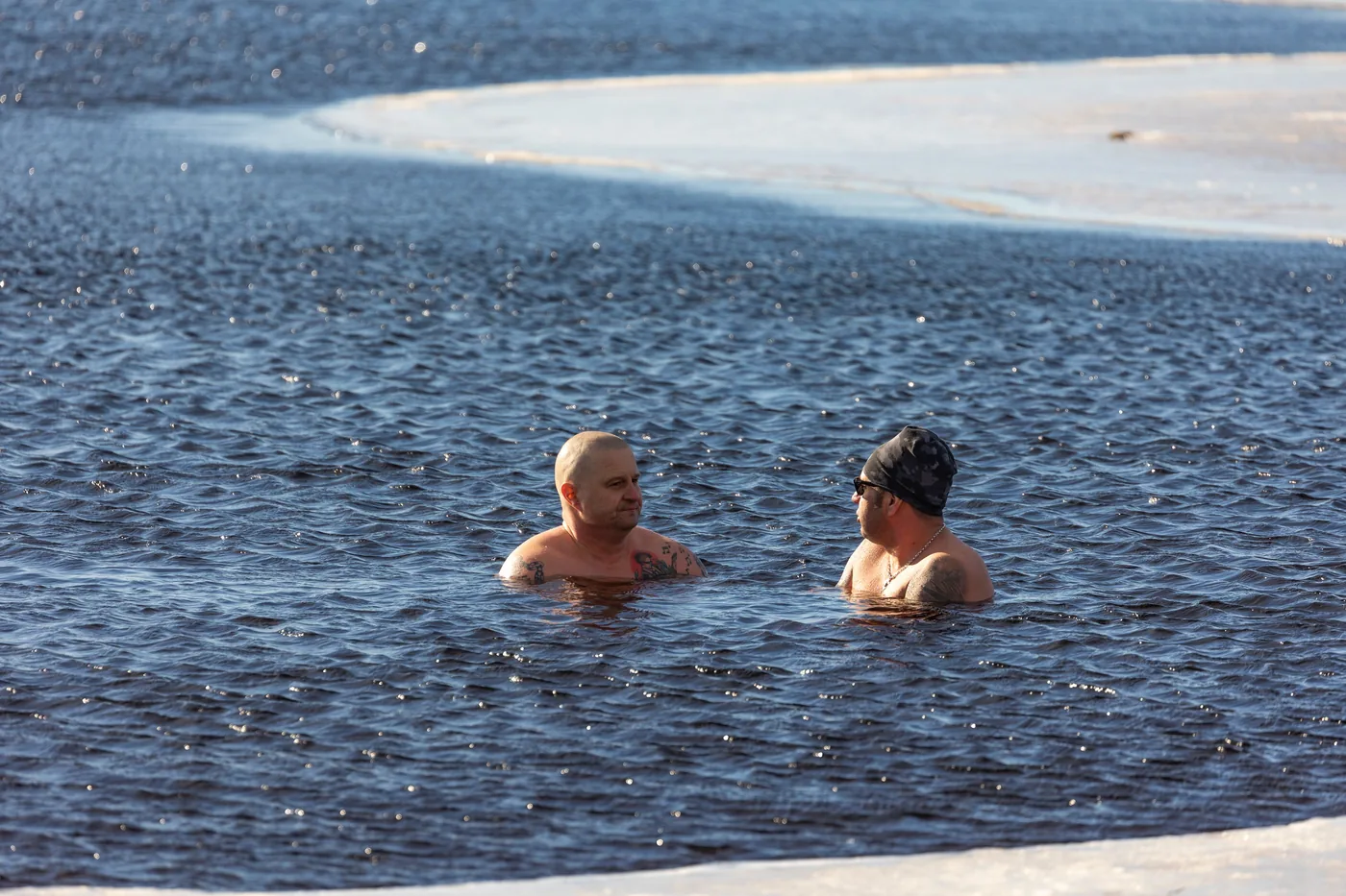 Two swimmers in icy winter water