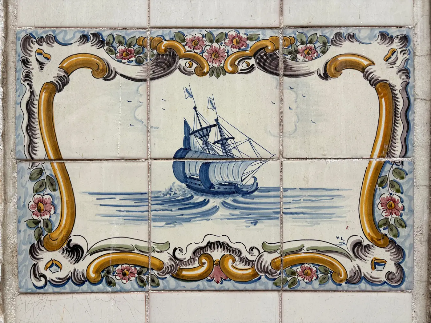 A hand painted Portuguese azulejo tile panel showing a sailing ship