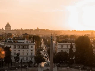 Rome at sunrise seen from Piazza del Popolo with the city's domes in the distance