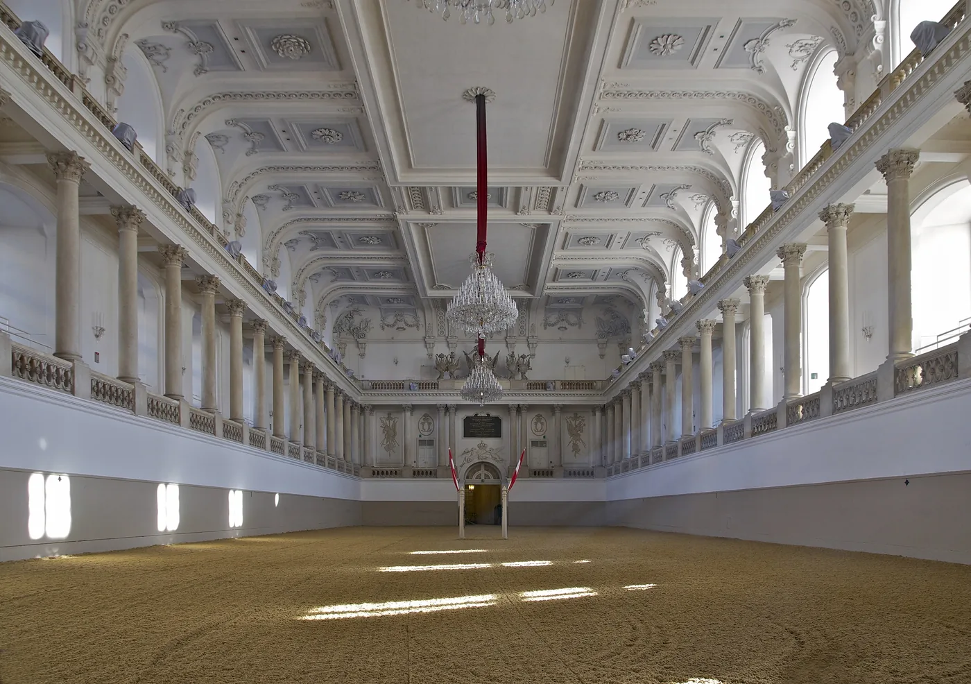 The white baroque hall and chandeliers of the Winter Riding School in Vienna
