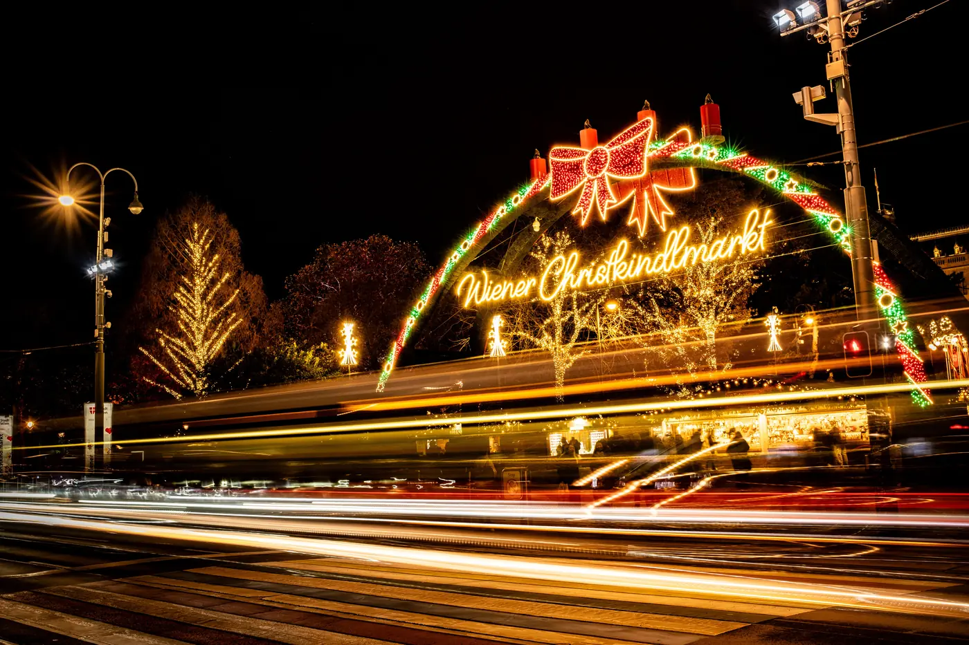 Glowing stalls and strung lights at a Vienna Christmas market after dark