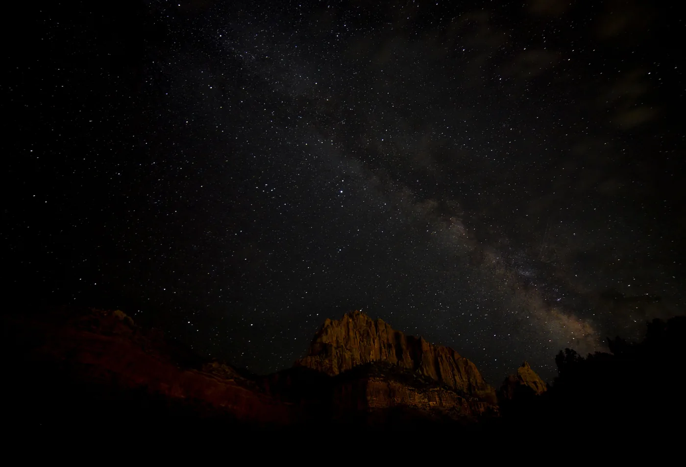The night sky over a moonlit sandstone peak in Zion National Park
