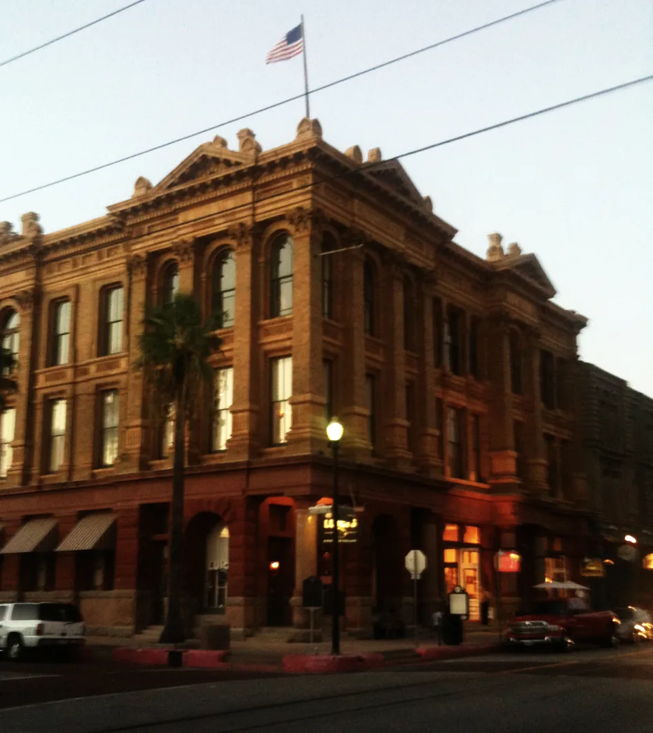 A historic brick building on The Strand in Galveston at dusk