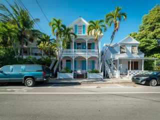 Historic wooden houses with palm trees on a street in Key West