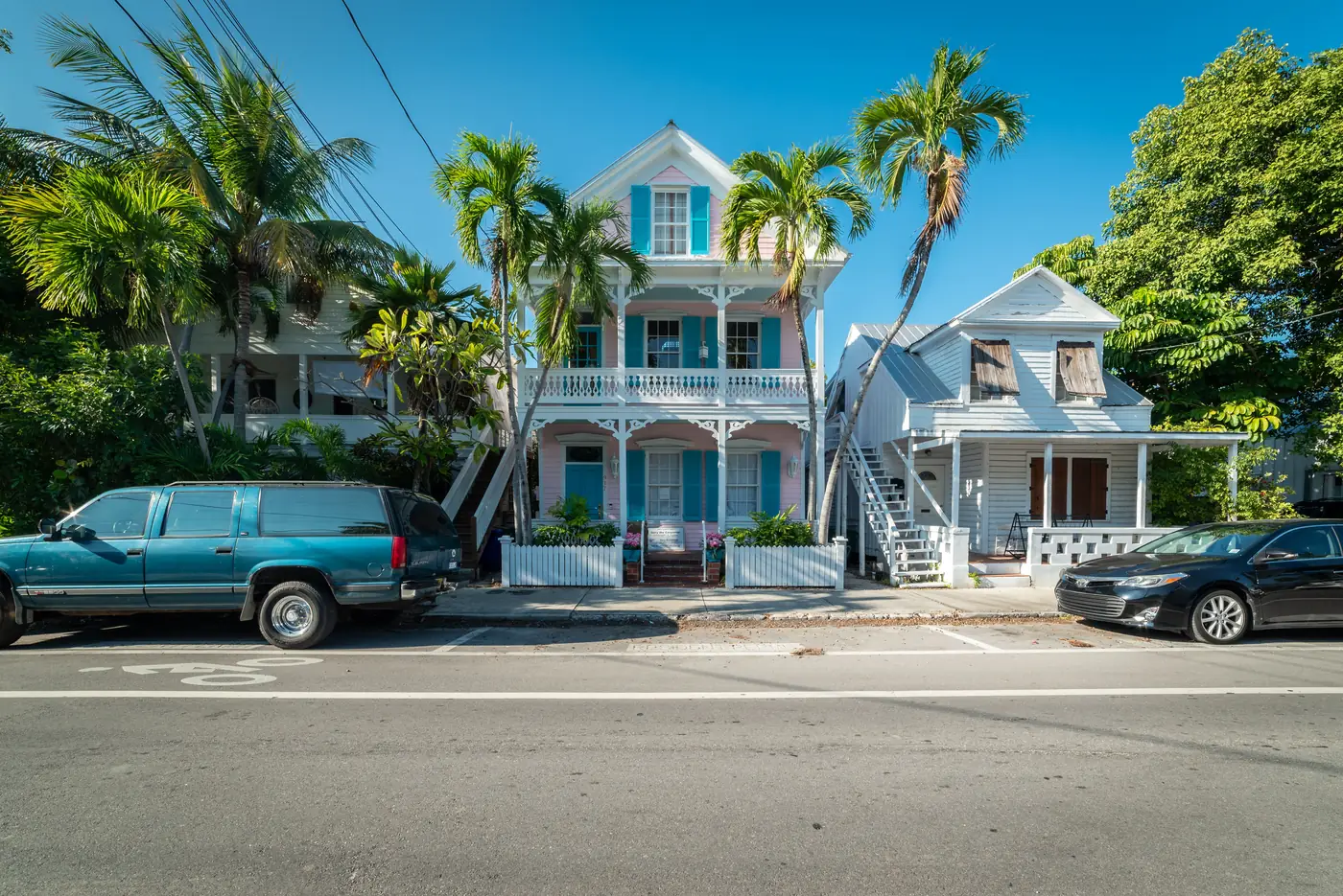 Historic wooden houses with palm trees on a street in Key West