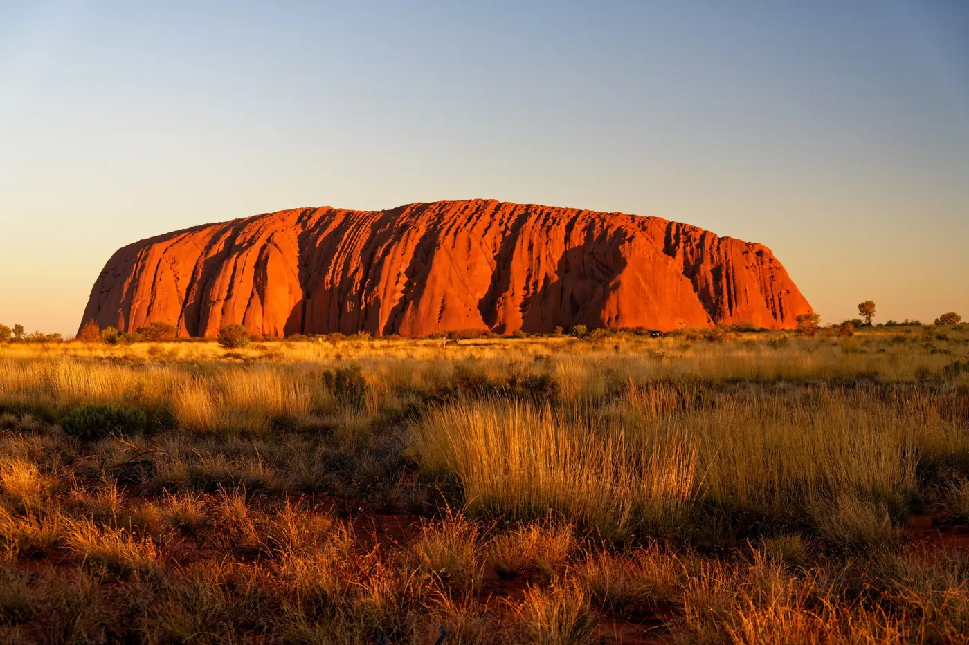 Uluru glowing red at sunrise in the Australian outback