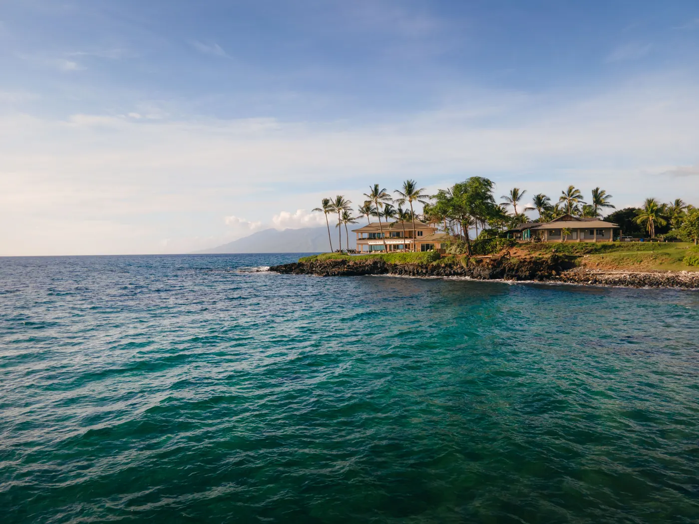 Oceanfront homes and palm trees on the coast of Kīhei, Maui
