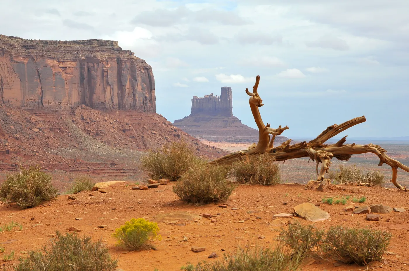 A butte rising above the desert floor at ground level in Monument Valley