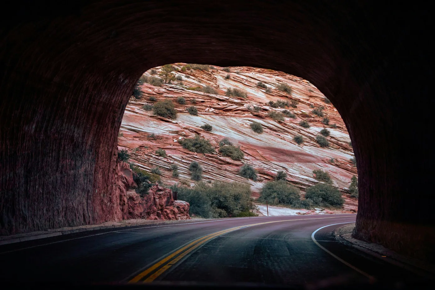 Looking out of the tunnel on the Zion Mount Carmel Highway onto white slickrock