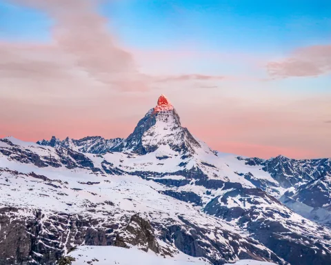 The Matterhorn glowing at sunrise above snowy ridges in Switzerland