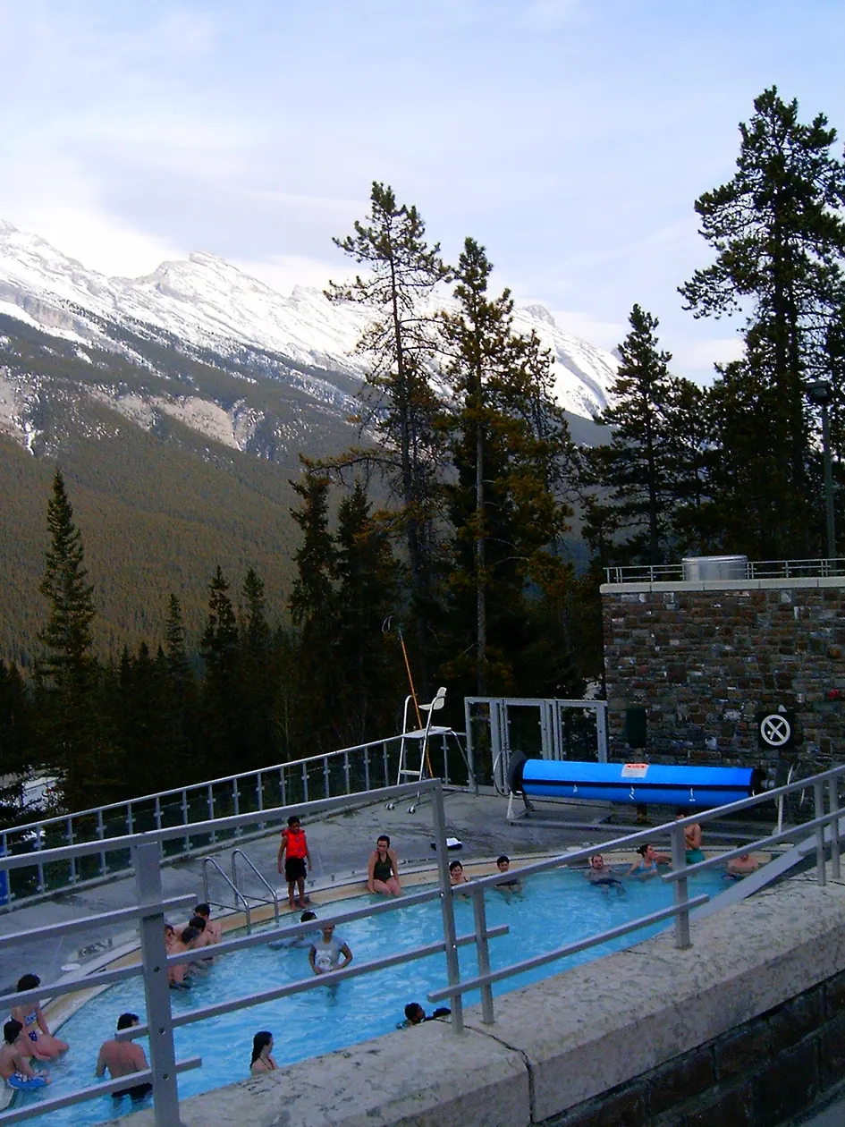 The outdoor pool at the Banff Upper Hot Springs with snowy peaks behind