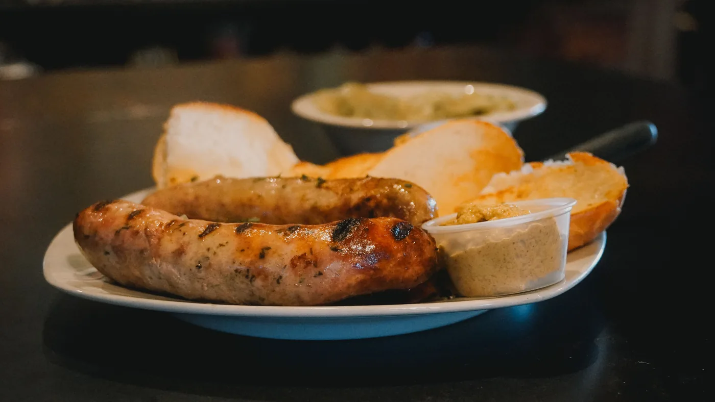 Grilled bratwurst with bread and mustard on a plate