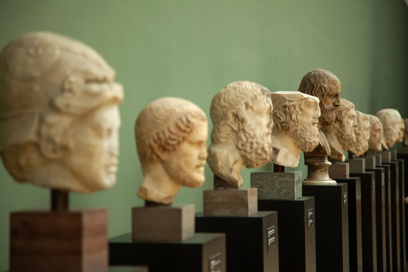 A row of ancient carved stone heads on display in a museum