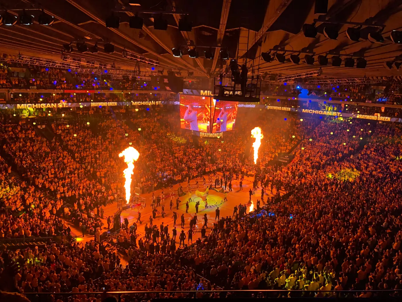 A packed basketball arena lit up before a game
