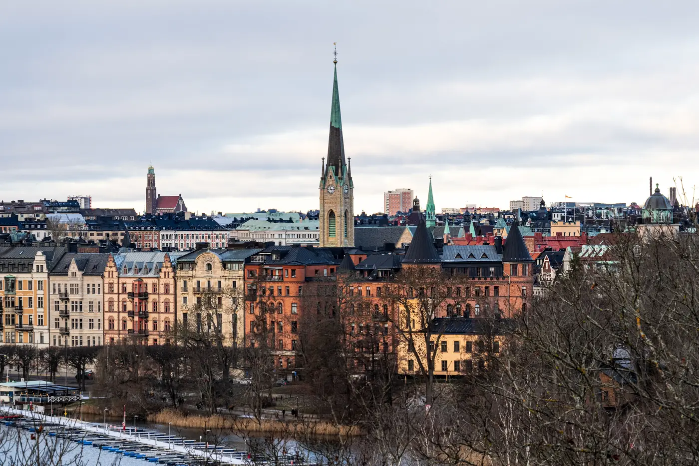 Stockholm rooftops and a church spire on a snowy winter day